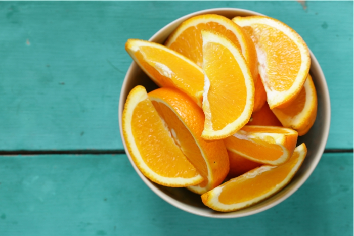 Laranjas cortadas sobre a mesa. Óleo da fruta pode ser benéfico em aromaterapia para gestantes.