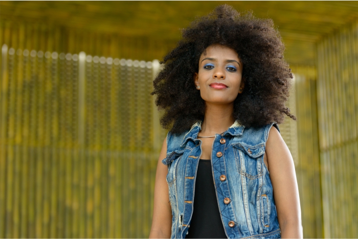 Mulher com couro cabeludo afro ou crespo, cuidados e fisiologia da pela negra.