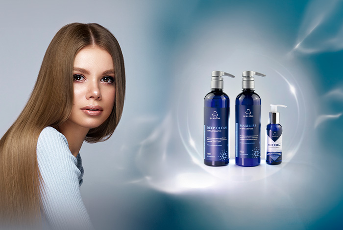Nanocristalização: quais os benefícios para o cabelo? 1 Mulher com cabelos longos e alinhados ao lado de produtos capilares em frascos azuis, destacando cuidado e tratamento dos fios.