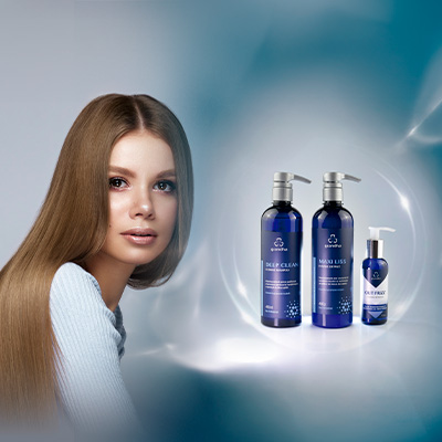 Mulher com cabelos longos e alinhados ao lado de produtos capilares em frascos azuis, destacando cuidado e tratamento dos fios.