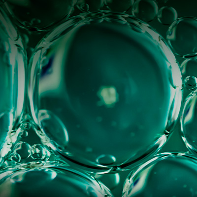 Macro de bolhas translúcidas em líquido, formando textura fluida que remete a processos químicos ou biotecnológicos.