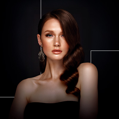 Retrato de mulher com cabelo estilizado e maquiagem sofisticada, em fundo escuro com estética elegante e moderna.